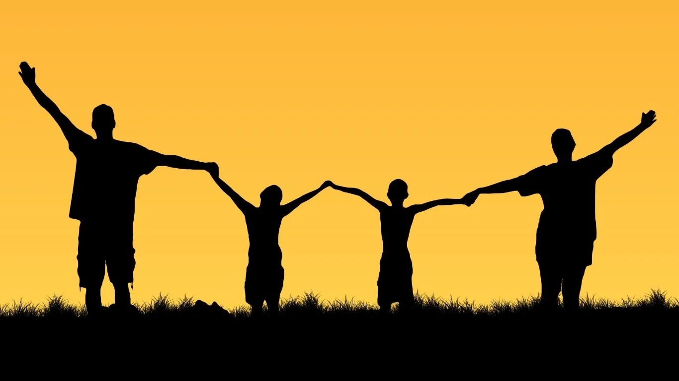 Eine Familie als Silhouette vor einem warmen Sonnenuntergang