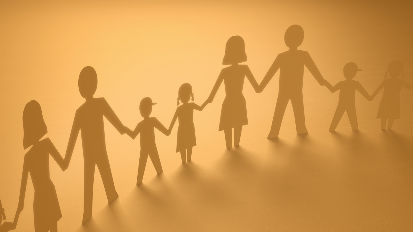 Papierfiguren einer Familie, die sich in warmem Licht an den Händen halten